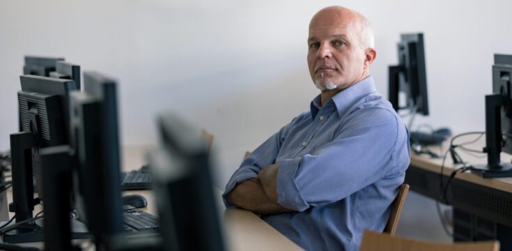 man-sitting-at-desk-crossed-arms